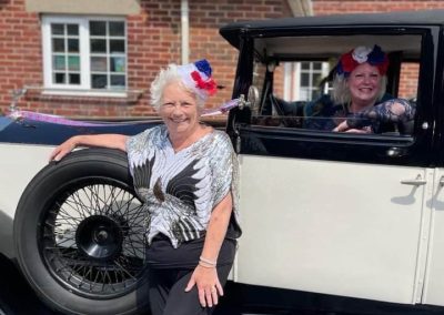 Janice Moth founder of The Glamour Club in a 100 year old Rolls Royce car with her mum standing in front